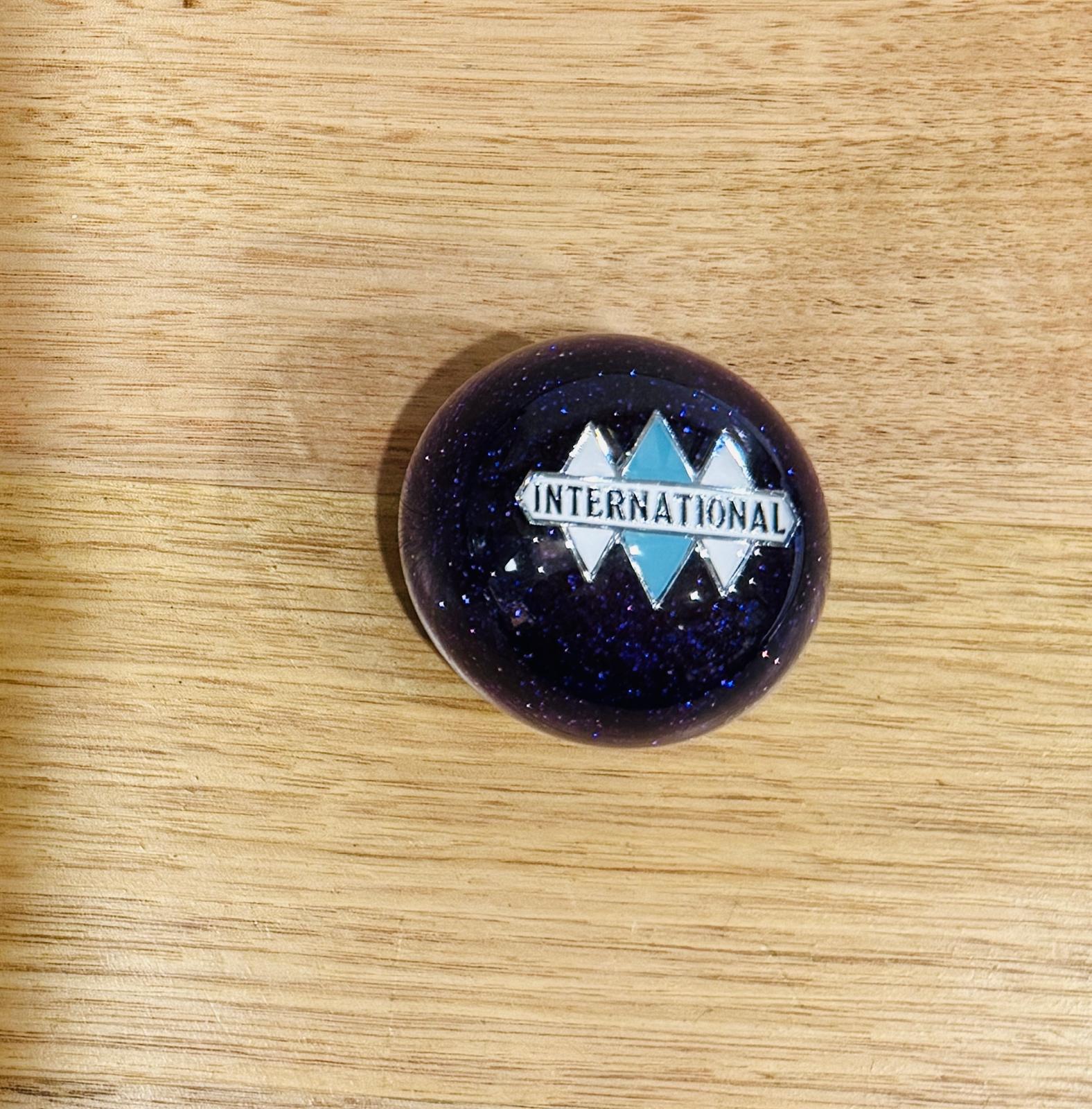 GS-IP1 : Purple Glitter Round Gear Shifter Knob with white/silver/blue INTERNATIONAL logo detail